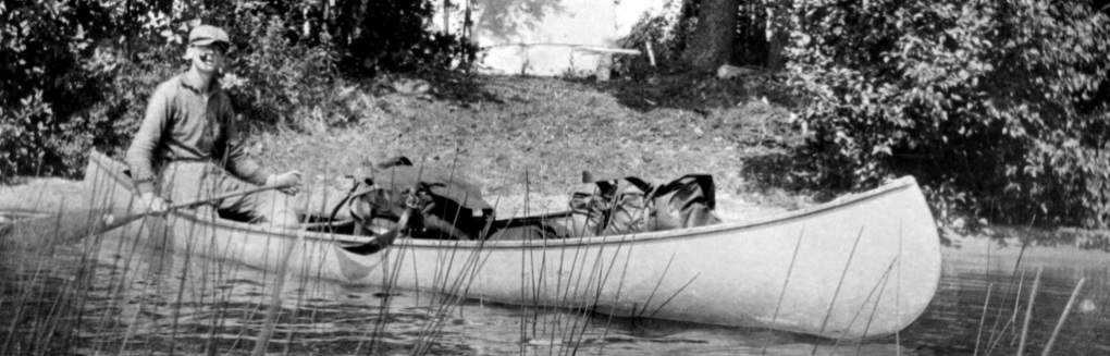 Tom Thomson smoking a pipe in a canoe.